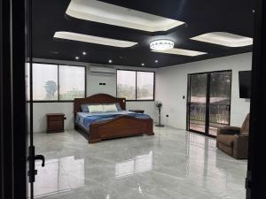 a bedroom with a bed and a couch and windows at Brisa marina in Moín
