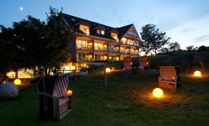 ein großes Haus mit Stühlen und Lichtern im Hof in der Unterkunft Hotel Pabst in Juist