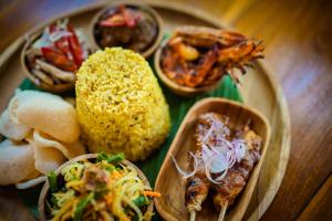 a plate with different types of food on a table at Pertiwi Bisma 1 in Ubud