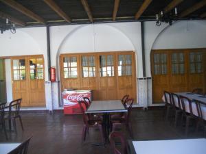 a restaurant with tables and chairs and a coke machine at Camping Fuente de Piedra in Fuente de Piedra