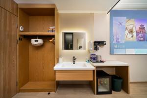 a bathroom with a sink and a mirror at The Screen Hotel Hangzhou East St ation-Zhanongkou Metro in Hangzhou +16 photos