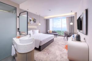 a bedroom with a bed and a sink and a mirror at Wahid Prime Hotel Salatiga in Salatiga +12 photos
