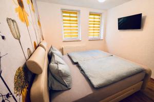 a small bedroom with a bed and a television at AltstadtQuartier Rudolstadt Ankommen l Bleiben in Rudolstadt