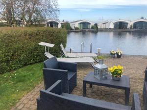 a patio with a table and chairs next to a lake at Aquaronde 119 in Lemmer