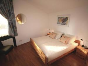 a bedroom with a bed with white sheets and a window at Aquaronde 119 in Lemmer
