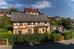 a large building with a house on top of it at Ferienhaus Rosalie Ruhiges Ferienhaus mit Garten direkt am Malerweg in Altendorf