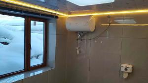 a bathroom with a window and a toilet at Snow Valley Xishui Dragon Soaring Inn in Wuchang +29 photos