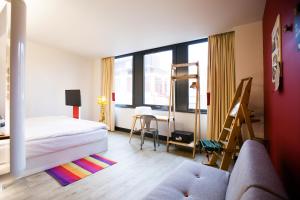 a bedroom with a bed and a desk and window at The Corner London City in London
