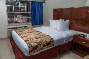 a hotel room with a bed and a window at Flamingo Express Hotel in Kissimmee