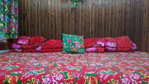 a large bed with red sheets and pillows on it at Snow Valley Xishui Dragon Soaring Inn in Wuchang