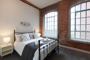 a bedroom with a bed and a brick wall at Raleigh Loft in Nottingham