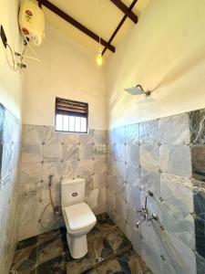 a bathroom with a toilet and a window in it at Villa SeaLoom in Galle