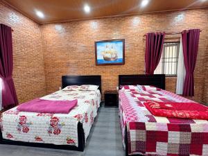 two beds in a bedroom with red and white blankets at Bối Villa Bảo Lộc in Minrong Sekang