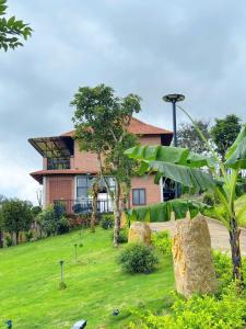 a house with a green lawn in front of it at Bối Villa Bảo Lộc in Minrong Sekang