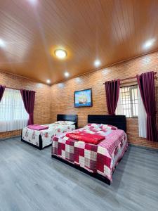 two beds in a large room with red curtains at Bối Villa Bảo Lộc in Minrong Sekang