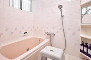 a bathroom with a tub and a toilet and a sink at R STAY Nagoya Atsuta in Nagoya +45 photos