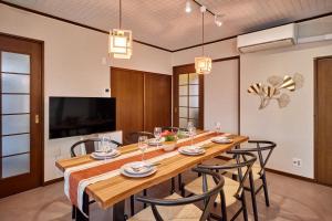 a dining room with a long wooden table and chairs at R STAY Nagoya Atsuta in Nagoya