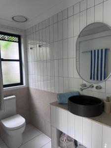 a bathroom with a toilet and a mirror at Mediterranean Studio & Garden View Private Pet Friendly in Brisbane