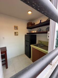 a kitchen with a sink and a black refrigerator at departamento Terraza Amecameca II in Amecameca de Juárez +17 photos