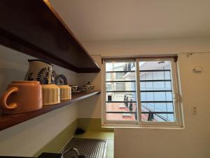 a kitchen with a window with a view of a balcony at departamento Terraza Amecameca II in Amecameca de Juárez