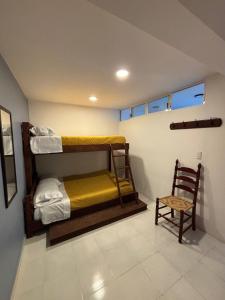 a room with two bunk beds and a chair at departamento Terraza Amecameca II in Amecameca de Juárez
