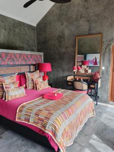 ein Schlafzimmer mit einem großen Bett und einem Spiegel in der Unterkunft H616 Vintage Elegance with sea view in Kubutambahan + 29 Fotos