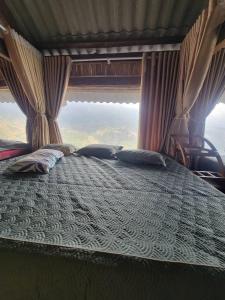 a bed with two pillows on it in a room at Đồi Gió Homestay in Bắc Yên