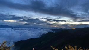 a view of a mountain with clouds in the sky at Đồi Gió Homestay in Bắc Yên