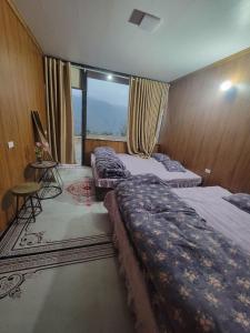 a bedroom with two beds and a large window at Đồi Gió Homestay in Bắc Yên