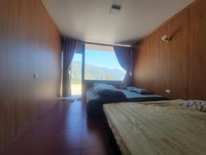 a bedroom with two beds and a large window at Đồi Gió Homestay in Bắc Yên