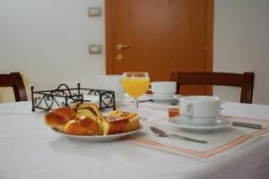 a table with a plate of bread and a glass of orange juice at P&P Assisi Camere in Bastia Umbra