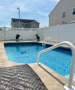 a swimming pool with two people in the water at Waterfront with Heated Pool, Dock & Outdoor Fun ! in Beach Haven West