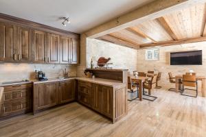 a kitchen with wooden cabinets and a dining room at Villa Sky in Mimice