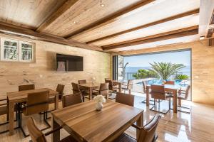a dining room with tables and chairs and a large window at Villa Sky in Mimice