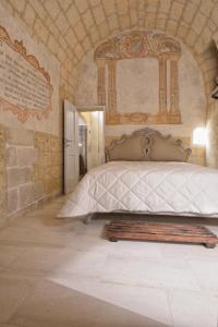 Un dormitorio con una cama en una pared de piedra. en B&B Masseria Conti Filo, en Altamura 115 fotos más