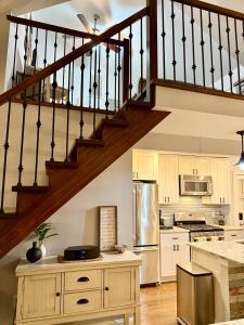 a kitchen with a staircase and a kitchen with white cabinets at Waterfront with Heated Pool, Dock & Outdoor Fun ! in Beach Haven West