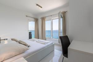 a bedroom with a bed and a desk and windows at Villa Sky in Mimice +90 photos