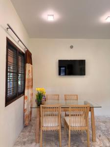 a dining room with a table and chairs and a tv at Baan Yanikar in Lampang