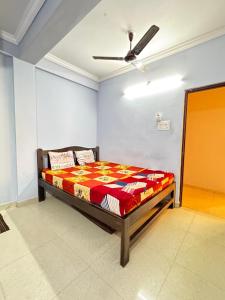 a bed in a room with a ceiling fan at Saichha Guest House in Calangute