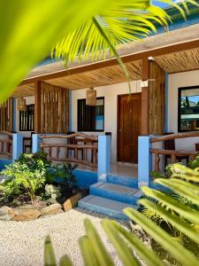 a home with a porch and stairs to the front door at Azuls Tourist Inn in San Vicente