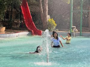 a group of people playing in a fountain in a pool at Aayush Resort Karjat in Kālundri
