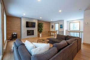 a living room with a large couch and a fireplace at Foosball table Spa & Sauna - Sommetoile in Saint Come