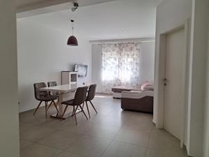 a living room with a table and chairs and a bedroom at Stars Palace - apartments and rooms in Jezera