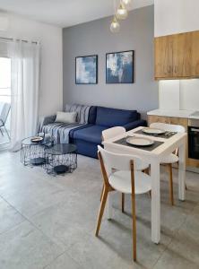 a living room with a blue couch and a table at Blue wave in Ierapetra +14 photos