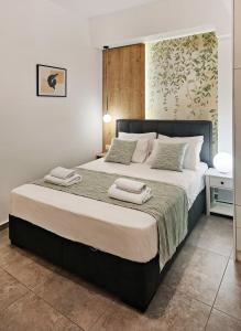 a bedroom with a large bed with two towels on it at Blue wave in Ierapetra