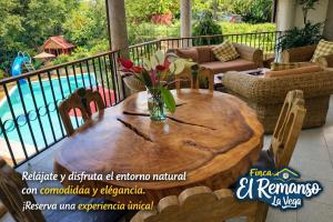 a wooden table with a vase of flowers on a porch at Finca El Remanso La Vega in La Vega