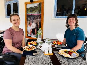 two women sitting at a table with food at Ella Ceylon Homies Hostel in Ella