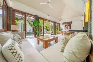 a living room with a white couch and a table at Mimosa - Private Pool Escape with Panoramic Views in Kerobokan