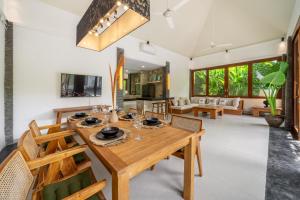 a dining room and living room with a wooden table and chairs at Mimosa - Private Pool Escape with Panoramic Views in Kerobokan