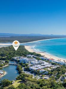 an hot air balloon flies over a beach at #2 Hastings Street in Noosa Heads